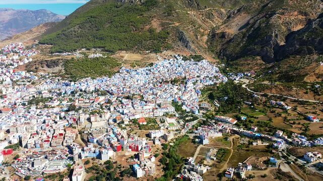 Aerial drone perspective of blue city Chefchaouen nestled in Rif mountains of Morocco.
