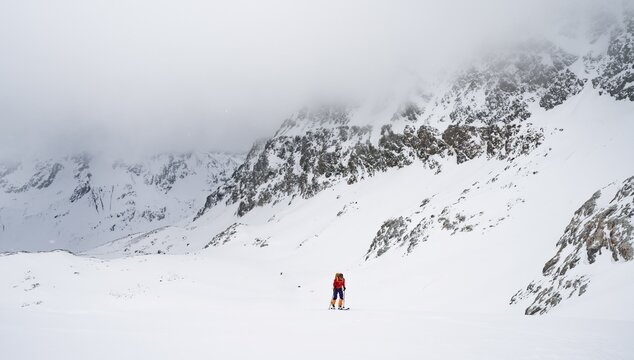 Ski tourer in wintry mountain landscape with cloudy mountain peaks, ascent to Piz Laviner, Grisons Haute Route, Albula Alps, Rhaetian Alps, Grisons, Eastern Switzerland, Switzerland