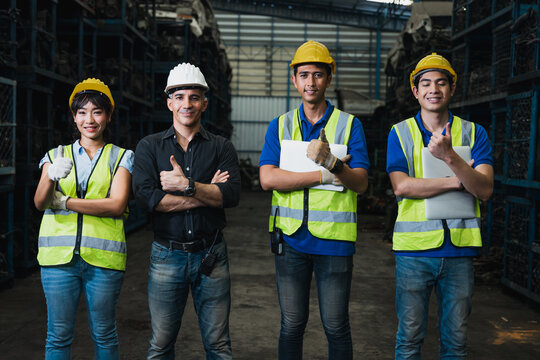 Warehouse team of workers and supervisor standing together in industrial storage