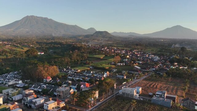 Aerial view of residential housing area in rural countryside with mountain landscape at sunrise