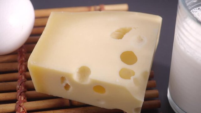 A close up view of delicious maasdam cheese with milk and an egg, motion footage of fresh dairy products ready for breakfast