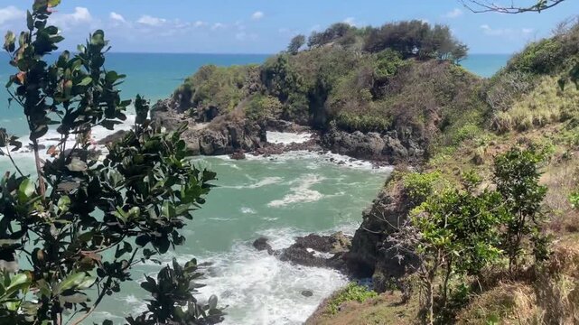 Ocean waves crashing against a rocky tropical headland