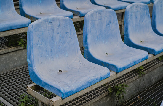 Old dirty plastic stadium seats in a row