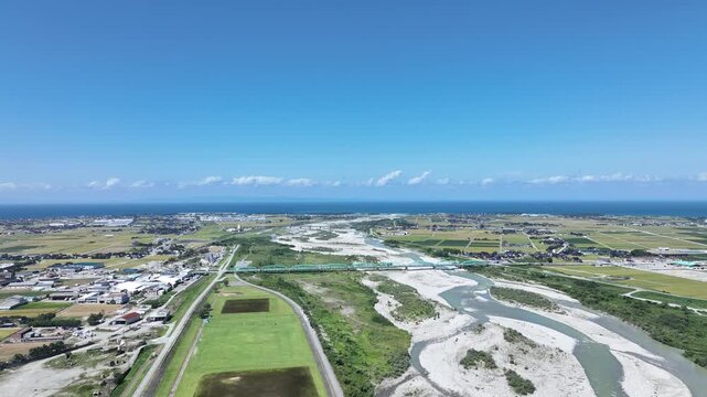 稲刈りの時期を迎えた日本の富山県にある黒部川扇状地の風景