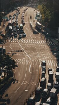 Busy urban traffic scene shows vehicles navigating intersections with pedestrians crossing streets in a vibrant city setting. Time-lapse, Seoul, South Korea