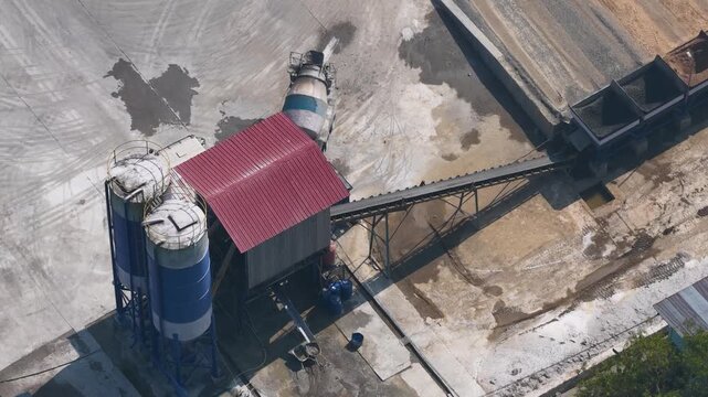Industrial machinery processing construction materials at a busy concrete batching facility