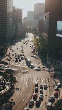 Vehicles navigate a bustling intersection in a cityscape, showcasing the dynamic flow of urban traffic during daylight. Time-lapse, Seoul, South Korea