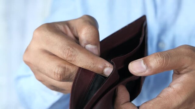 Close up video of person in blue shirt showing empty wallet concept of financial crisis and economic hardship