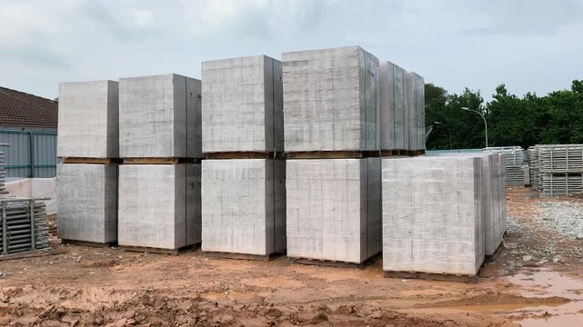 Stacked AAC block pallets sit on a construction site. These lightweight concrete blocks accelerate wall building and streamline workflow.