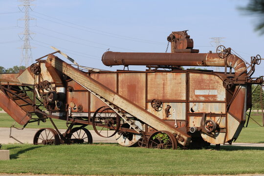 Rusted Antique Threshing Machine with Exposed Belts and Gears
