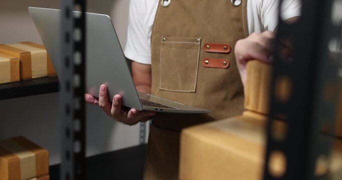 Small business owner managing packaging, inventory and order fulfillment in a modern workspace, representing e-commerce, warehouse organization, shipping and efficient business operations.