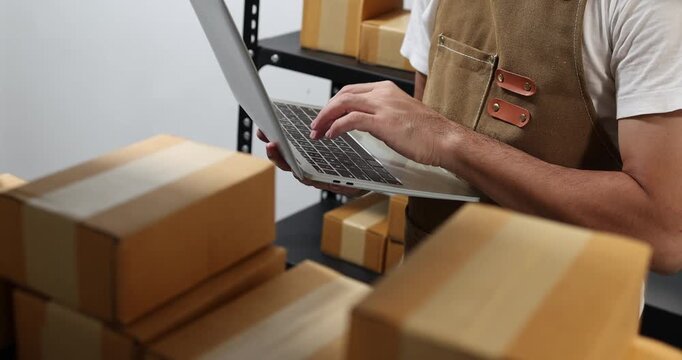 Small business owner managing packaging, inventory and order fulfillment in a modern workspace, representing e-commerce, warehouse organization, shipping and efficient business operations.