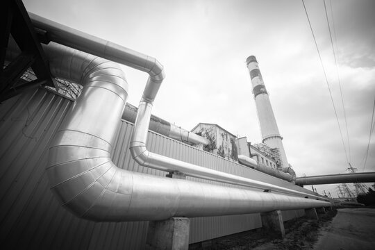 Industrial heating pipeline loop and factory smokestack monochrome background with copy space