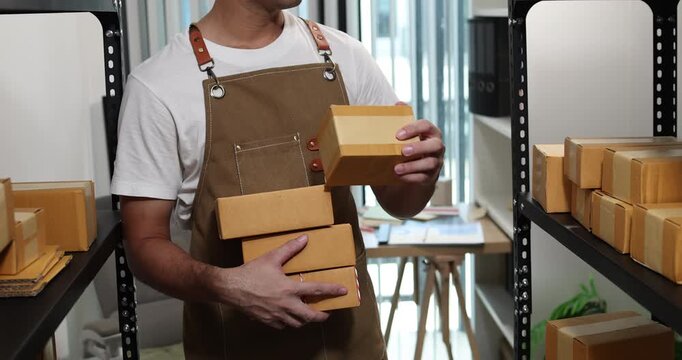 Small business owner managing packaging, inventory and order fulfillment in a modern workspace, representing e-commerce, warehouse organization, shipping and efficient business operations.