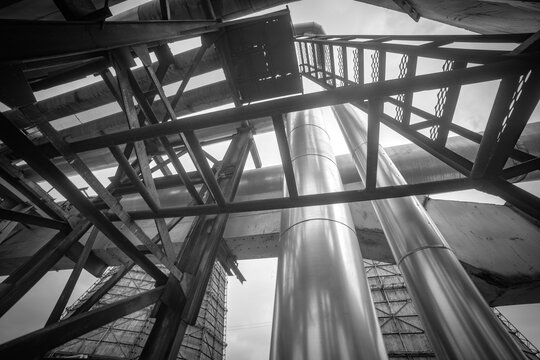 Abstract industrial metal scaffolding construction and pipelines monochrome background with copy space