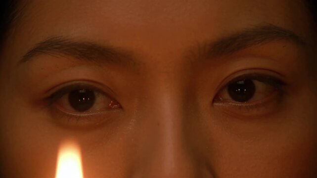 Intense, calm human eyes in warm candlelight, unblinking, fearless and deeply self-aware - Carl Jung Shadow Concept