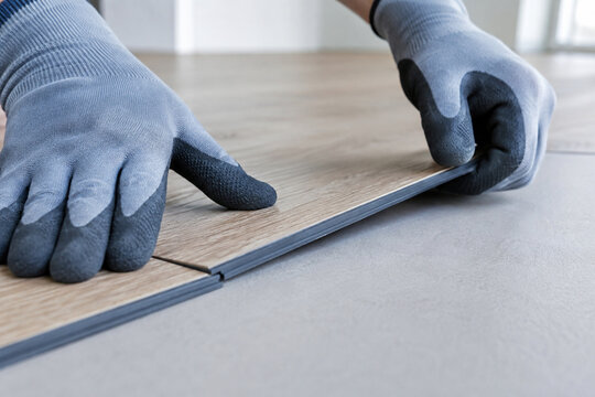 Close up of installer connecting SPC click lock flooring planks