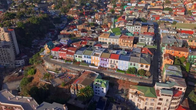 Aerial view of colorful residential houses situated on steep hillside in Valparaiso Chile during golden hour.