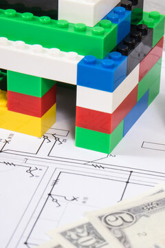 Small house made of toy blocks, housing plan with electric installation and dollar banknotes. Building or renting home