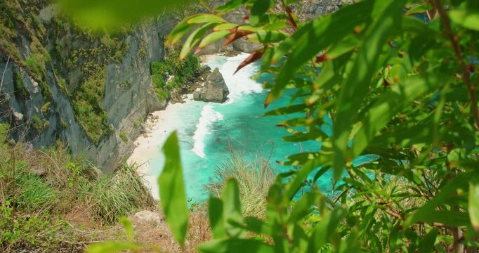 Spectacular view of tropical beach and turquoise sea framed by vibrant green trees in Nusa Penida Bali Island Indonesia
