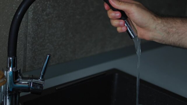 person washing dishes in a modern kitchen sink. Domestic chores, household duties, daily routine, and clean tableware concept with running water and blue plates.