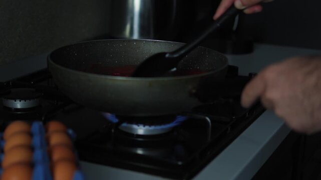 Cooking shakshuka, pouring tomatoes in a pan, and grating cheese. Homemade meal preparation, culinary recipe, and kitchen cooking process concept.
