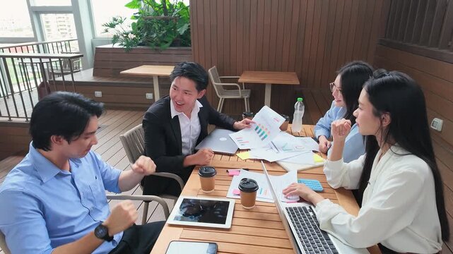 Asian Business Team Celebrating Success with High Fives on Office Terrace