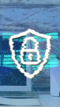 Animation of security padlock and chain icon against close up of equipment on office desk