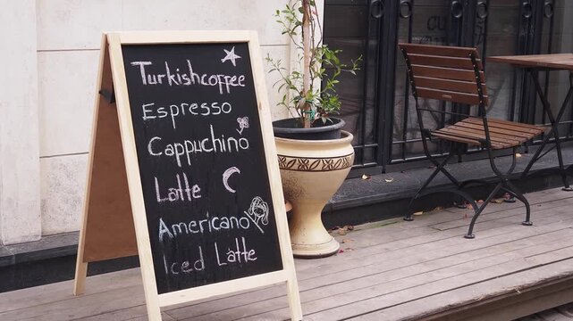 Chalkboard menu displaying coffee varieties outside cafe entrance