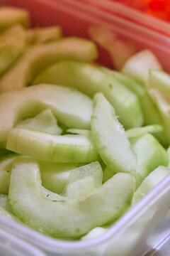 Rebanadas de pepino fresco en contenedor: concepto de alimentaci&oacute;n saludable y bienestar