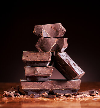 Chopped chocolate chunks stacked on a dark marble background