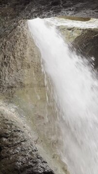 Stunning waterfall cascades down rocky cliff face creating powerful natural energy and beauty.