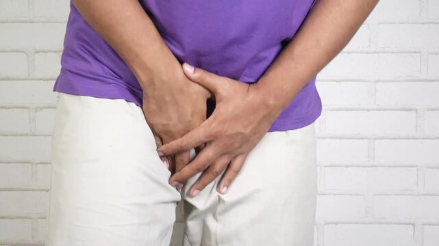 Man holding groin in pain, health problem concept, close up shot