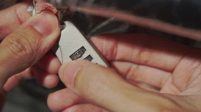 Close Up View of Hands Attempting to Brute Force a Combination Lock Padlock Number Dial