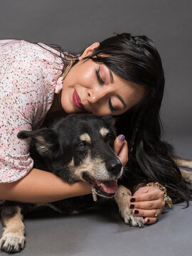 Woman Embracing Happy Dog in Studio Portrait