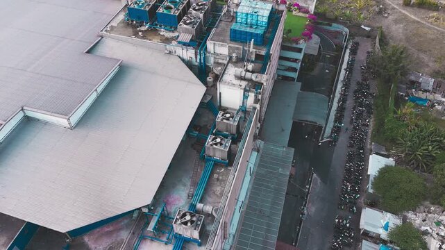Aerial view of data center rooftop equipped with heavy-duty cooling units, industrial ventilation fans, condenser systems, and pipes for temperature control. Ideal for commercial technology, industria