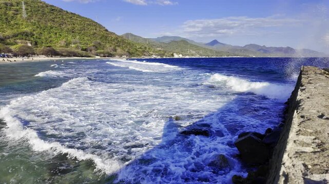 Slow Motion Ocean Waves Breaking Along Tropical Mountain Coast