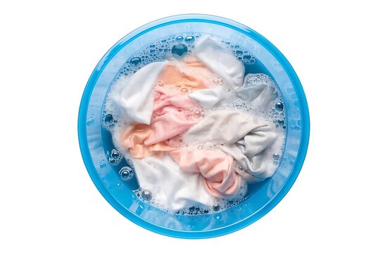 White and pink laundry soaking in a blue plastic basin with soap bubbles