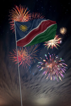 Waving National flag of Namibia and holiday fireworks in night sky