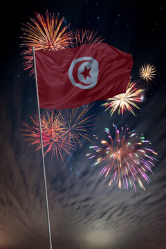 Waving National flag of Tunisia and holiday fireworks in night sky
