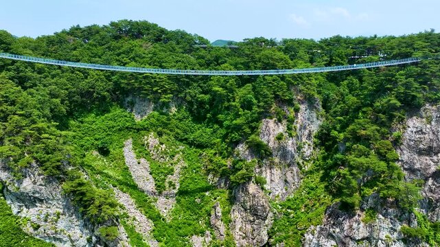 Aerial drone view of Wonju Sogeumsan Suspension Bridge and green mountains in South Korea