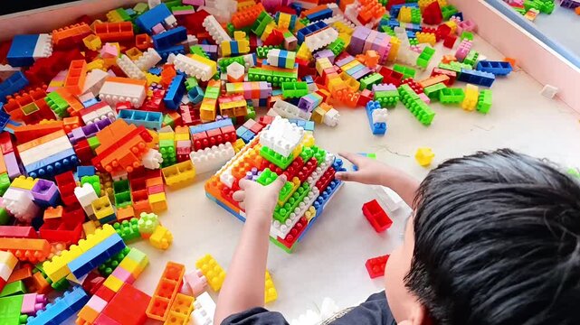 Asian Boy Playing Plastic Building Blocks Colorful Educational Toy Creative Construction Activity Kids Indoor Playroom High Angle Shot