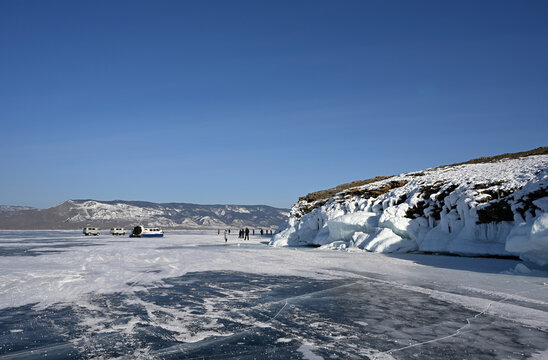 Tourists on winter Lake Baikal near the Kobylaya Golova Peninsula.
