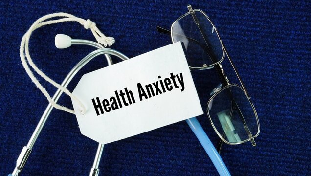 Stethoscope, glasses and a paper tag with the word Health anxiety. ongoing fear and belief that you have or will soon develop a serious, life-threatening medical illness