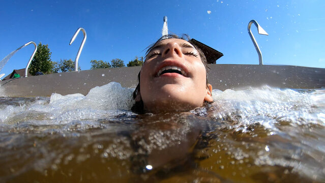A young girl enjoying water jets in a swimming pool