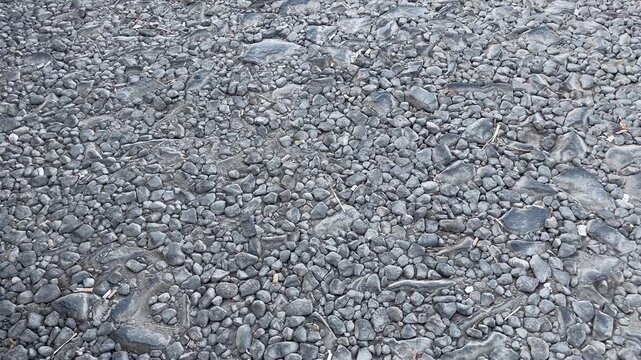 High Angle View of Damaged Asphalt Road Texture with Scattered Gravels