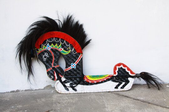 Traditional Indonesian Javanese horse props made from woven bamboo, featuring colorful hand-painted patterns, black horsehair details, and distinctive cultural craftsmanship displayed against a white 