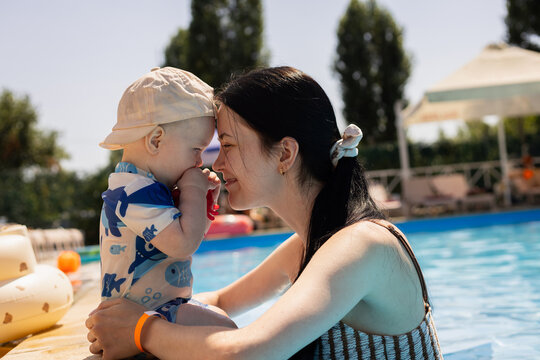 Mother and baby bonding by the pool on a sunny summer day
