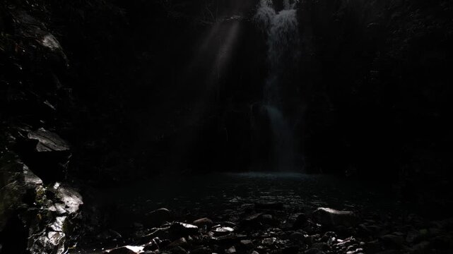 Mysterious Waterfall Deep Inside Ioki Cave in Kochi, Japan with Sunbeams and Dripping Water &ndash; Aerial Drone Footage
