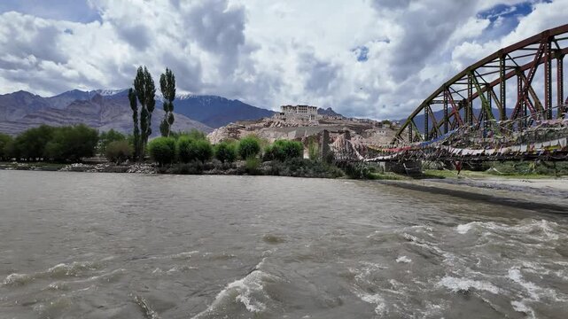 Ladakh, India : Panoramic footage of the bridge with prayer's flag above Indus river connecting to Stakna Gompa,  Buddhist monastery on the hilltop of  Ladakh, India with arid mountain